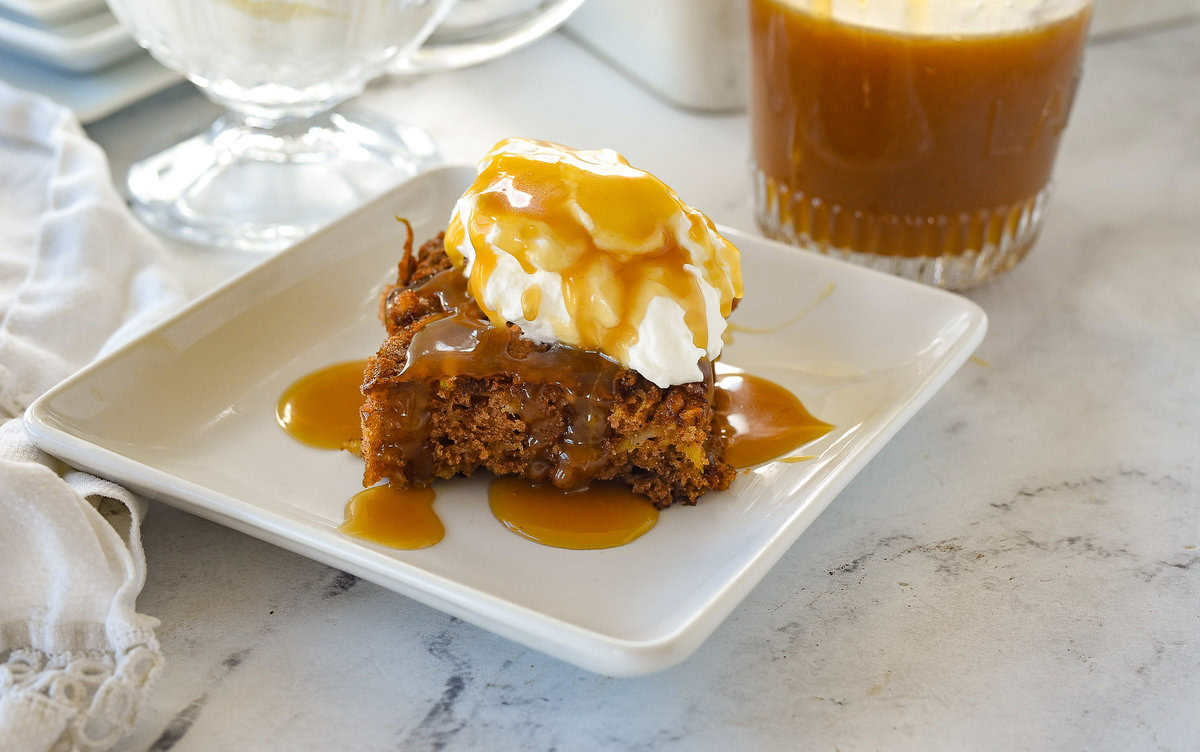slice of apple cake with whipped cream and caramel sauce on top