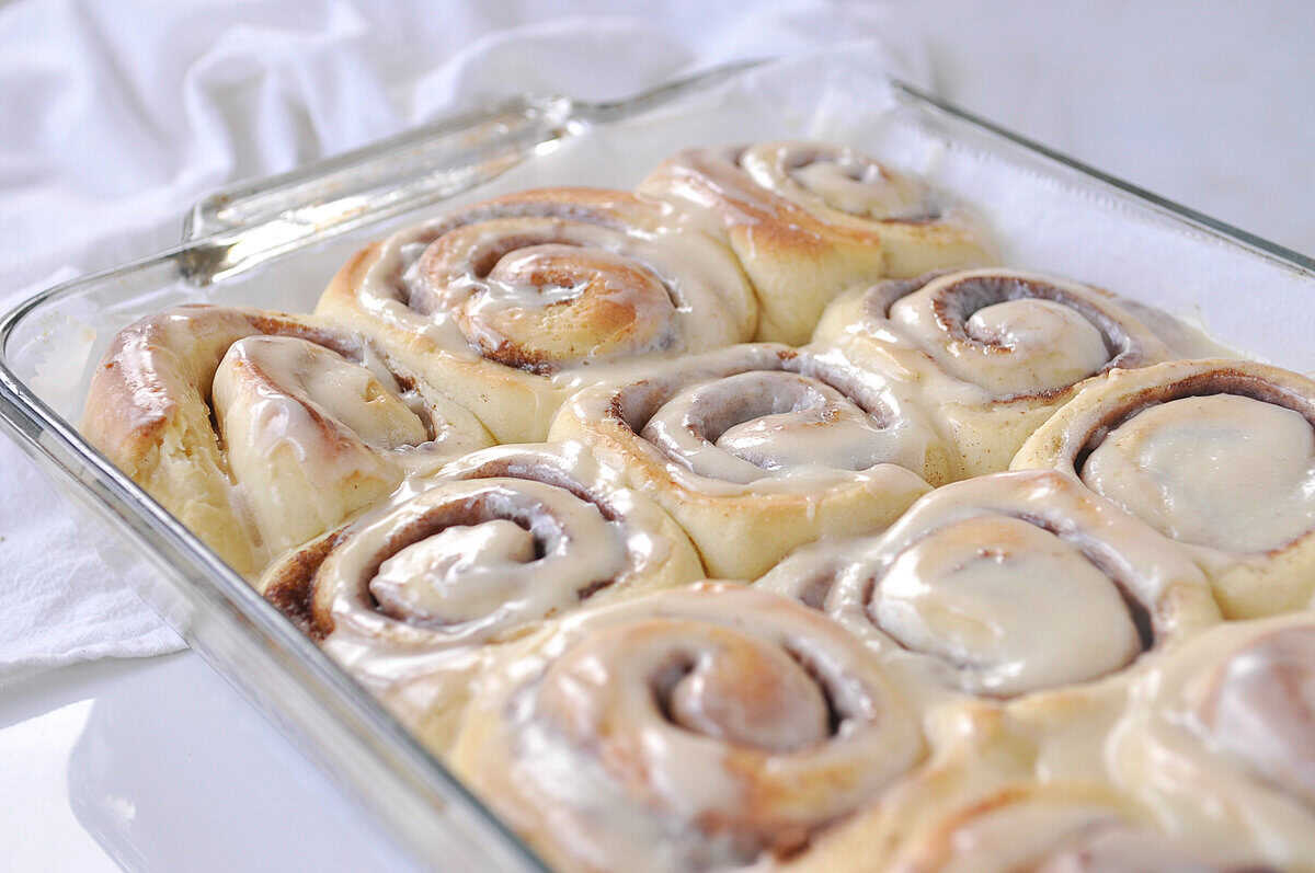 frosted cinnamon rolls in a baking pan