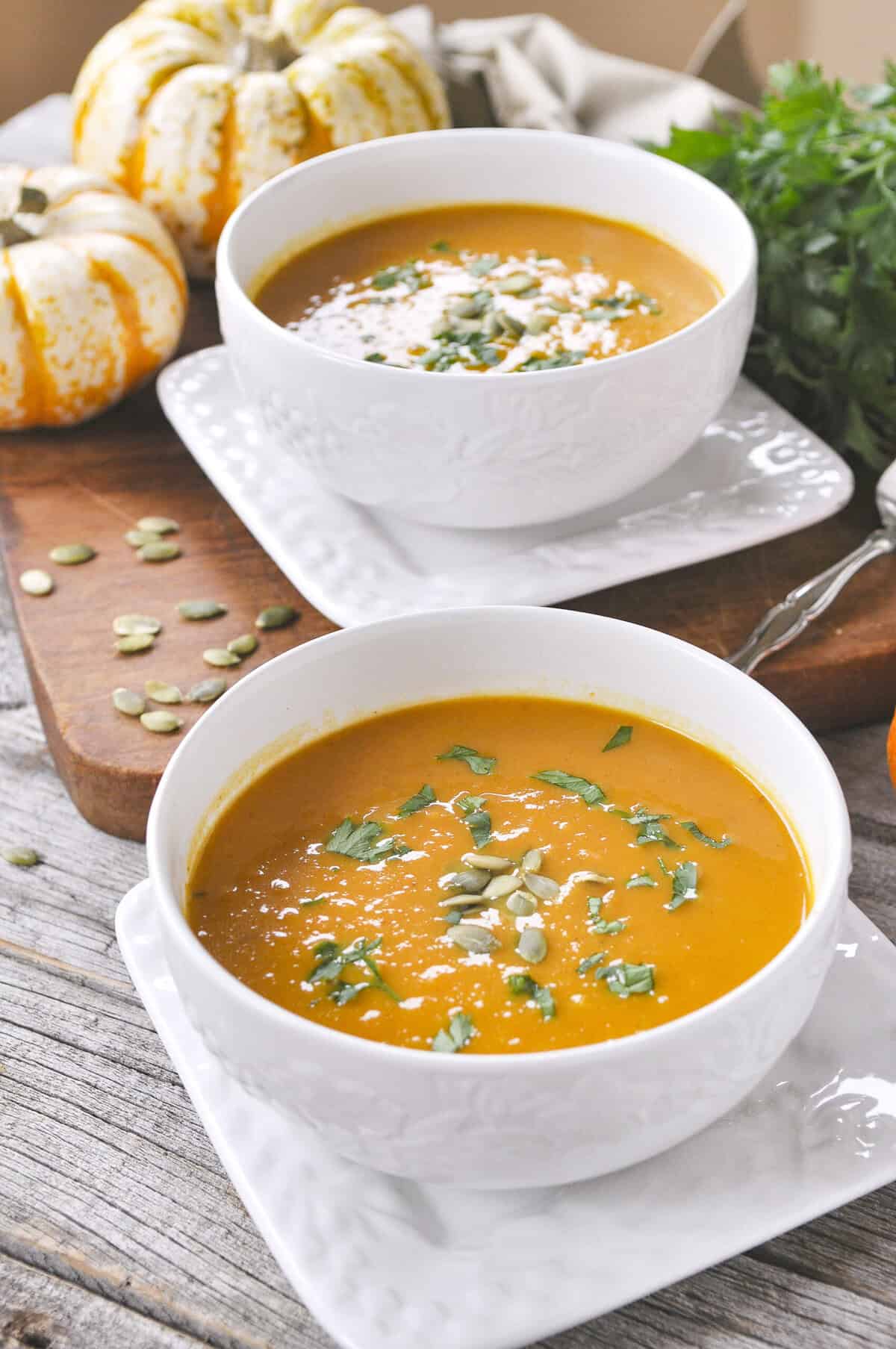 pumpkin curry soup two white bowls full of pumpkin curry soup