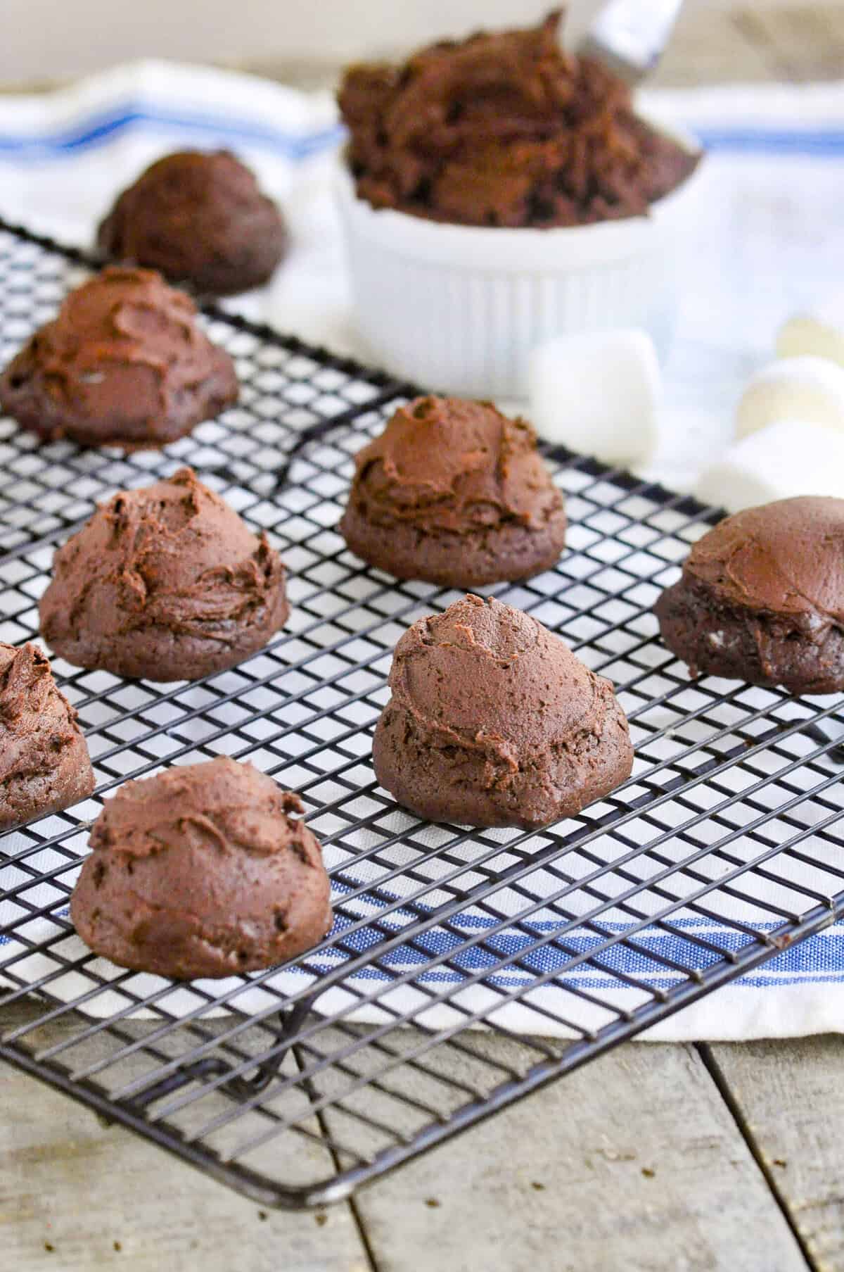 chocolate marshmallow cookies on a cooling rack on top of a kitchen towel