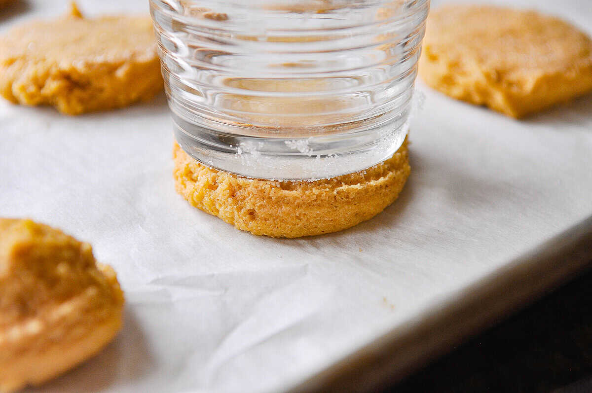 glass pressing down on pumpkin sugar cookie dough