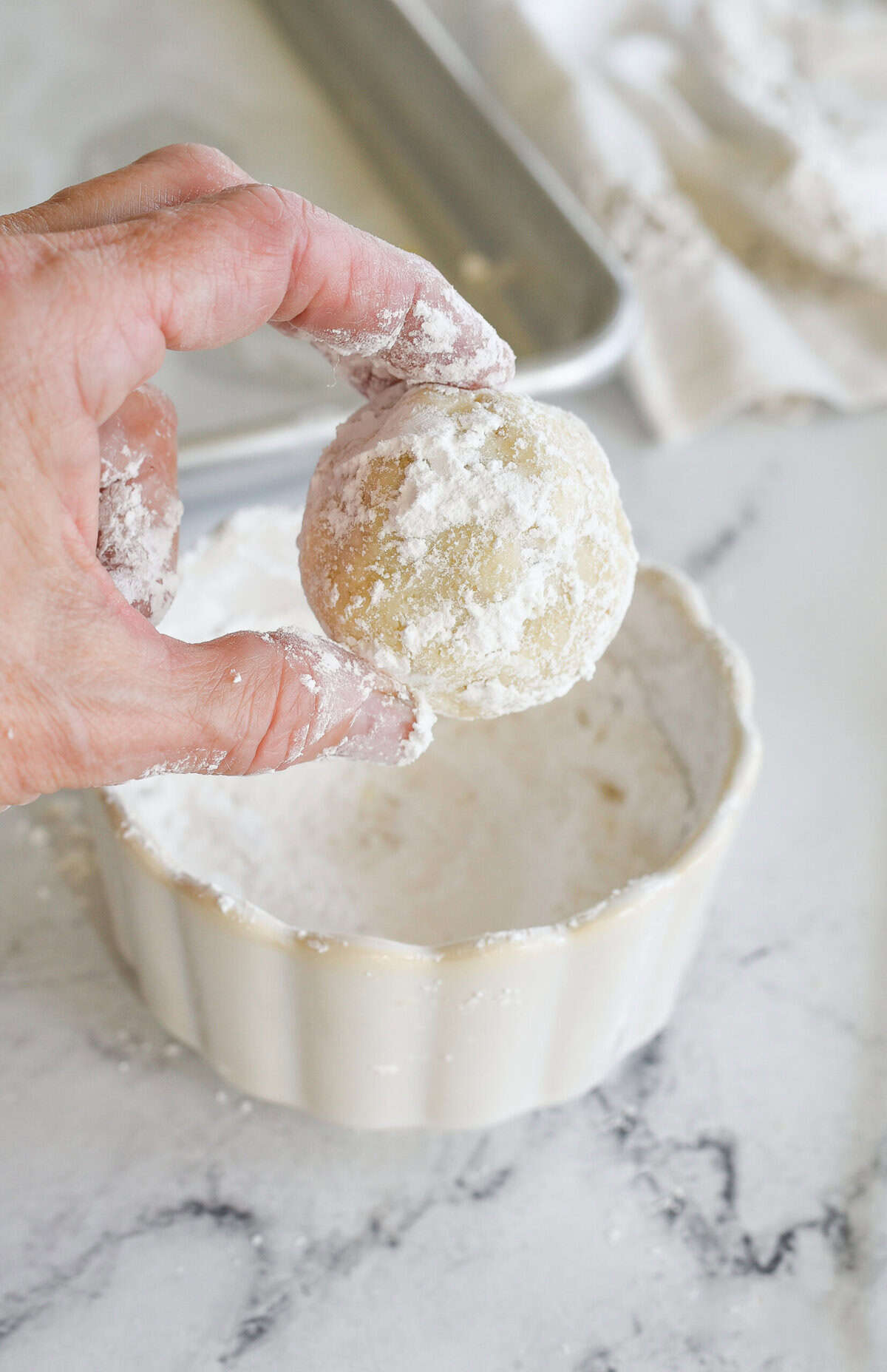 dipping cookie into powdered sugar