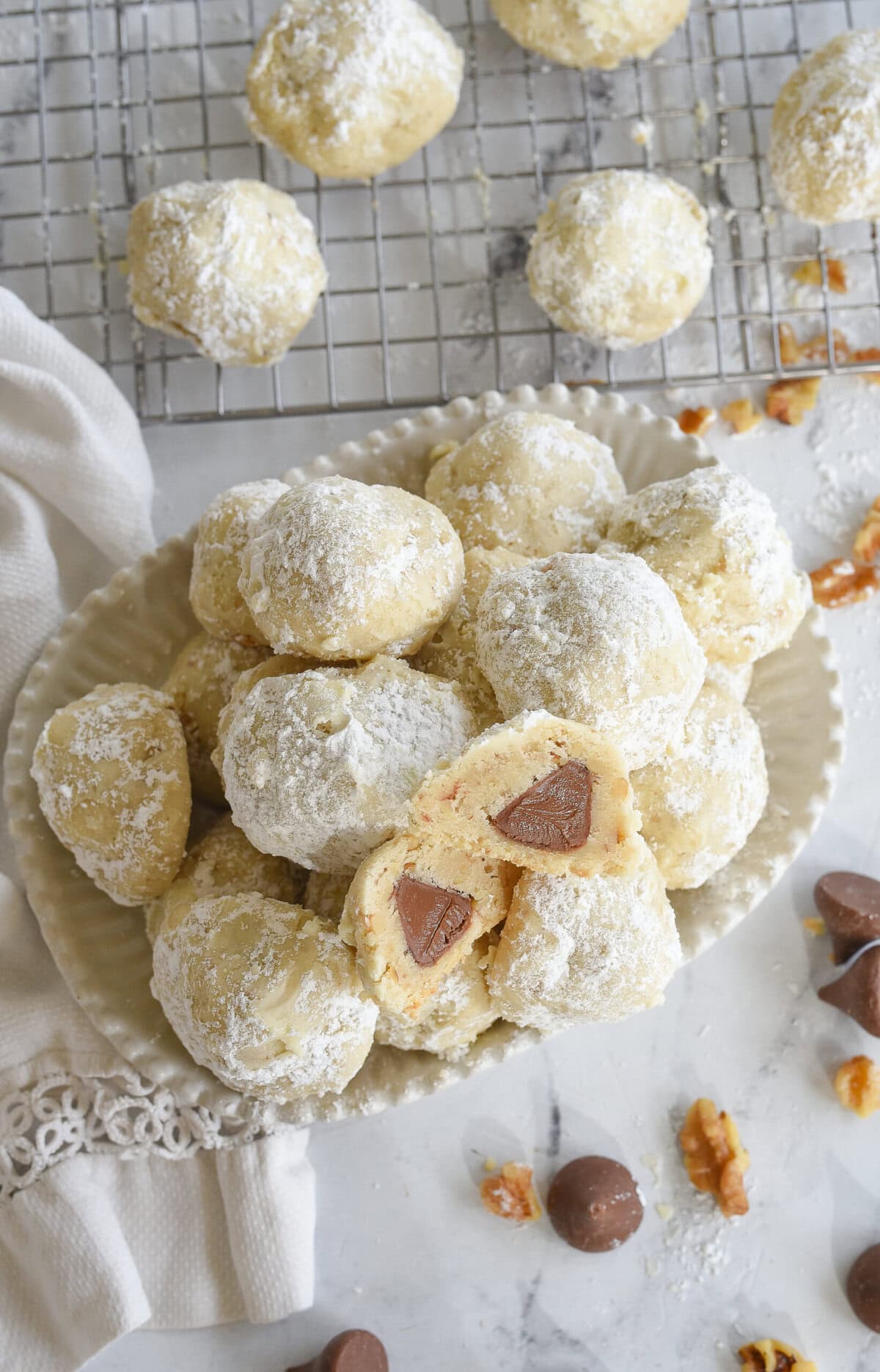 overehad shot of snowball cookies with one cookie cur in half