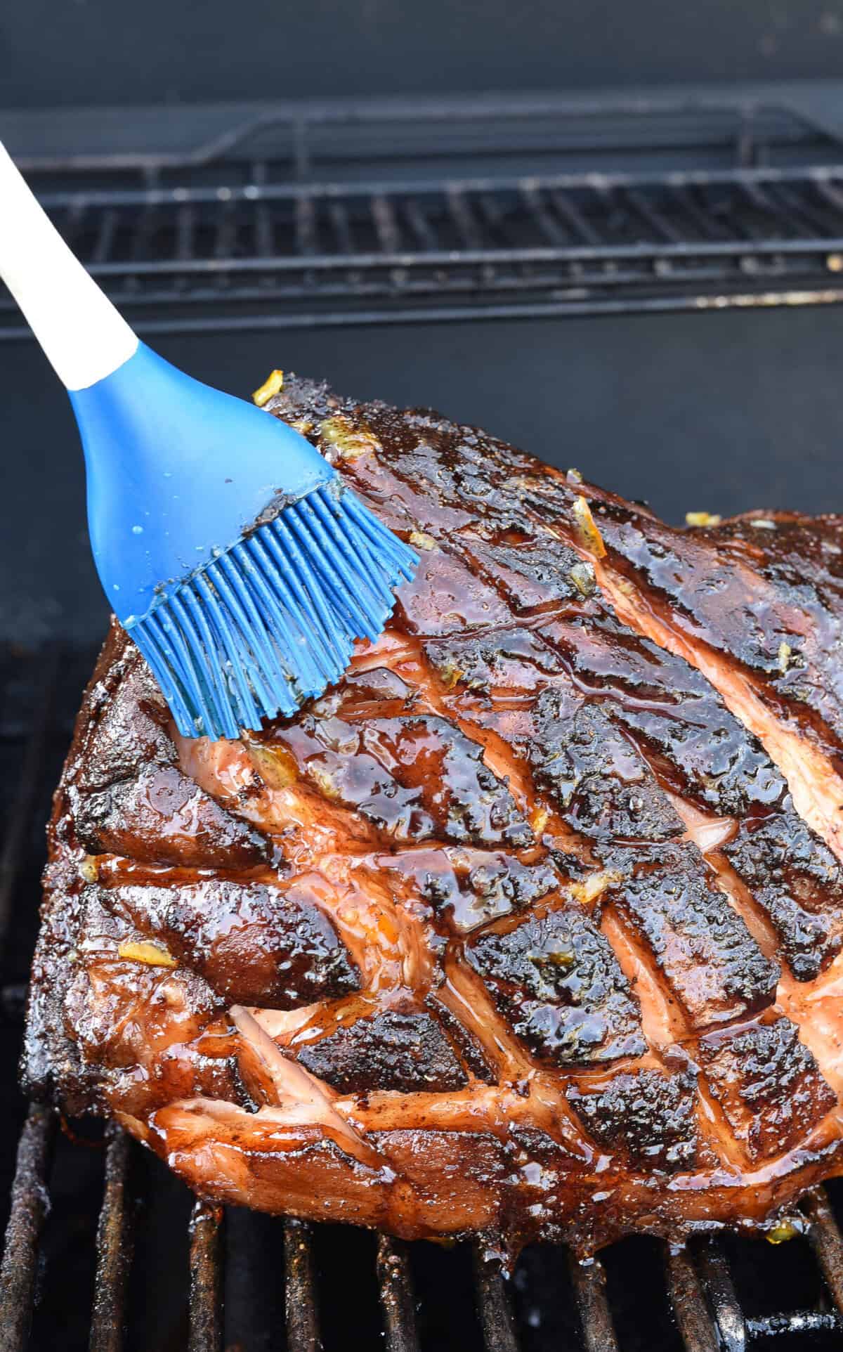 brushing ham on the grill