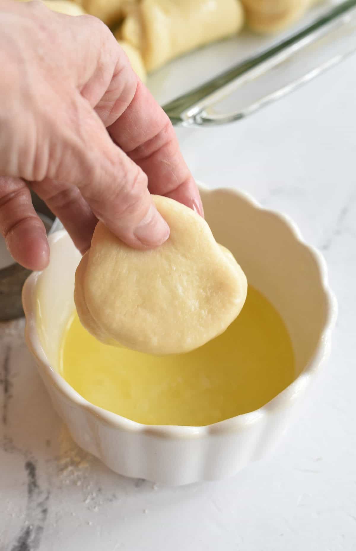 dipping roll dough in butter
