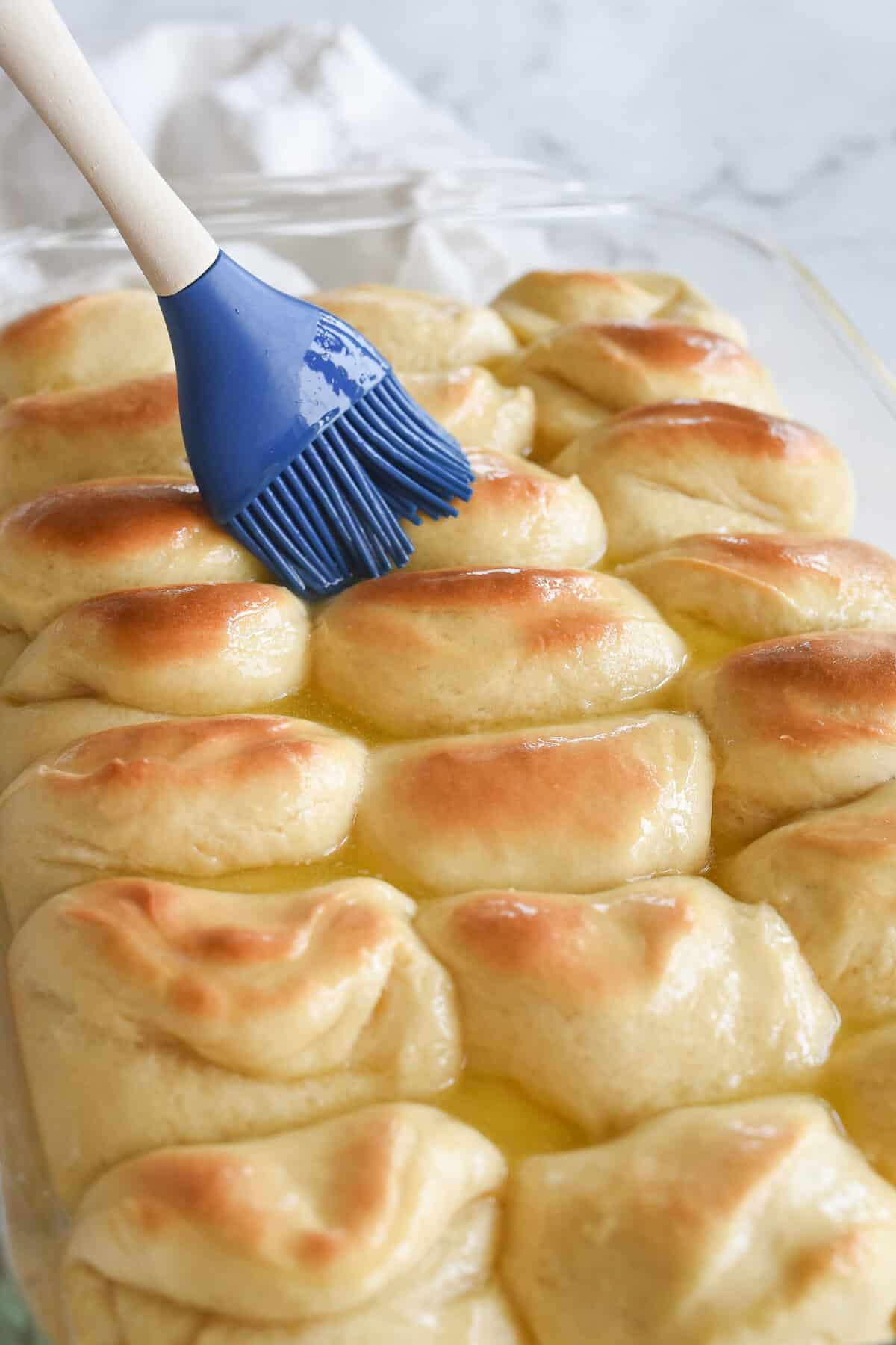 brushing baked rolls with melted butter