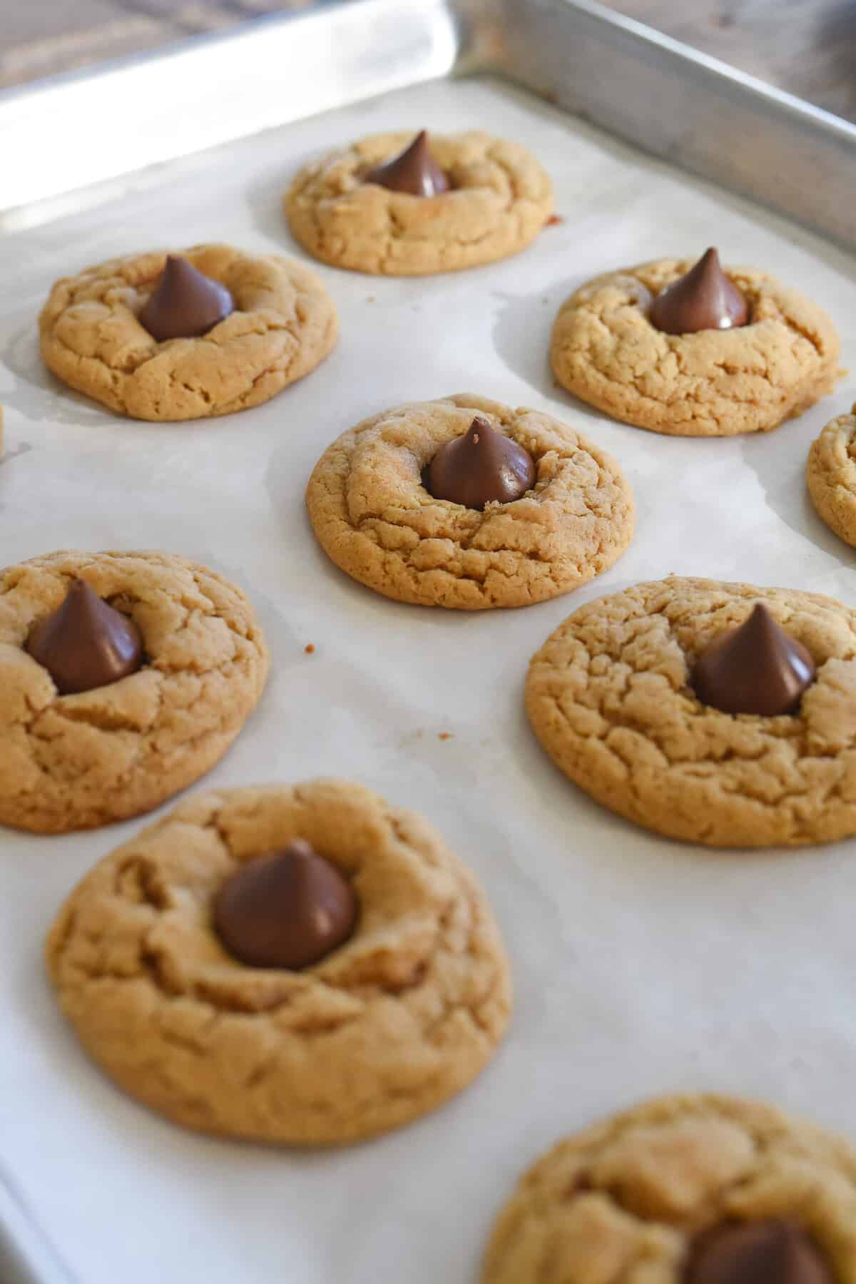 pb blossoms on a baking sheet with chocolate kisses in the middle
