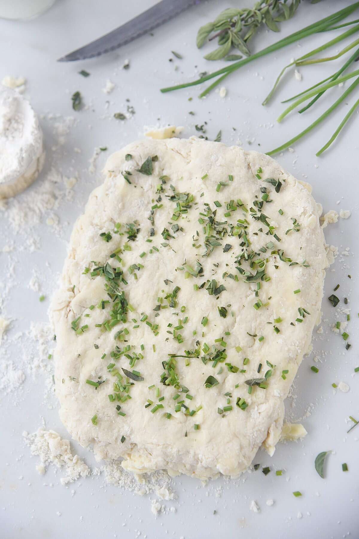 overhead shot of biscuit dough with herbs on top