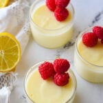 glass dshes of lemon posset with raspberries on top