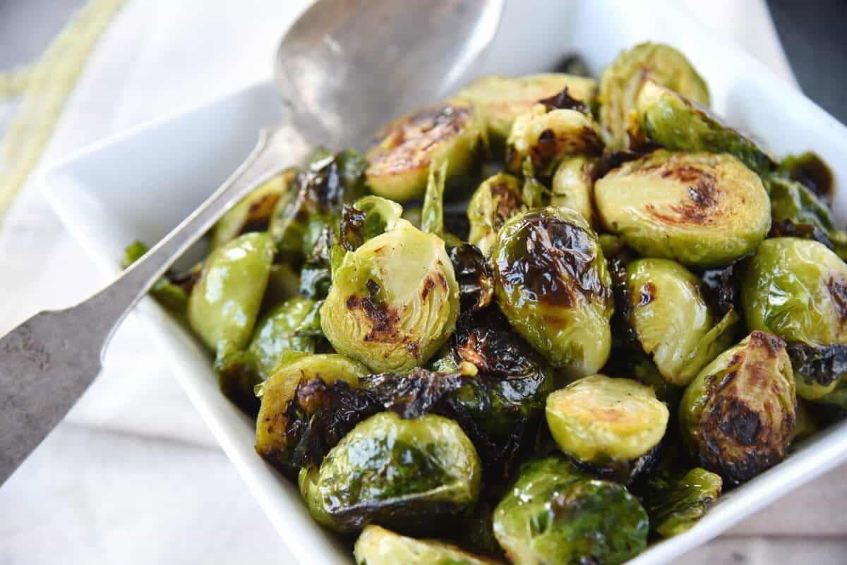 spoon in a bowl of roasted maple brussels sprouts