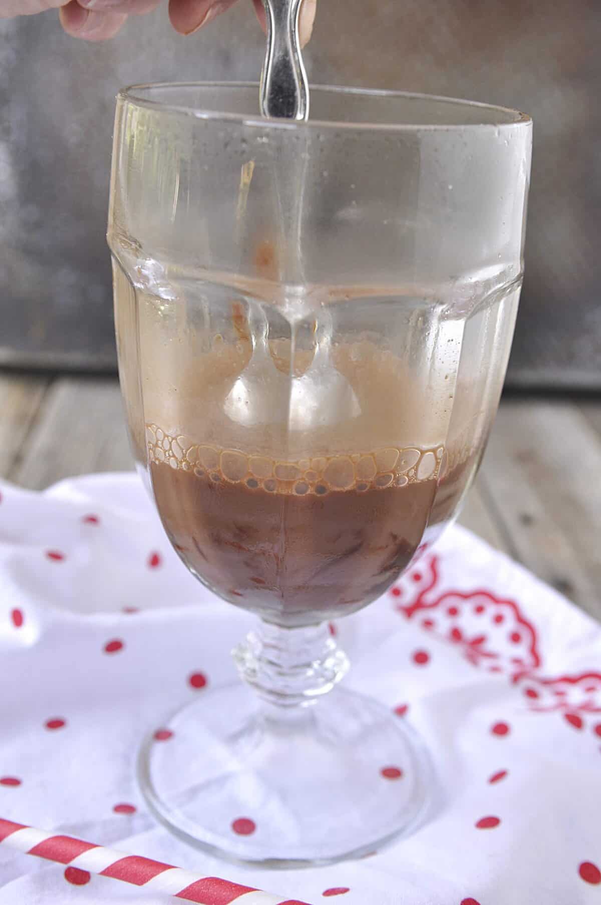 adding soda water to chocoalte syrup