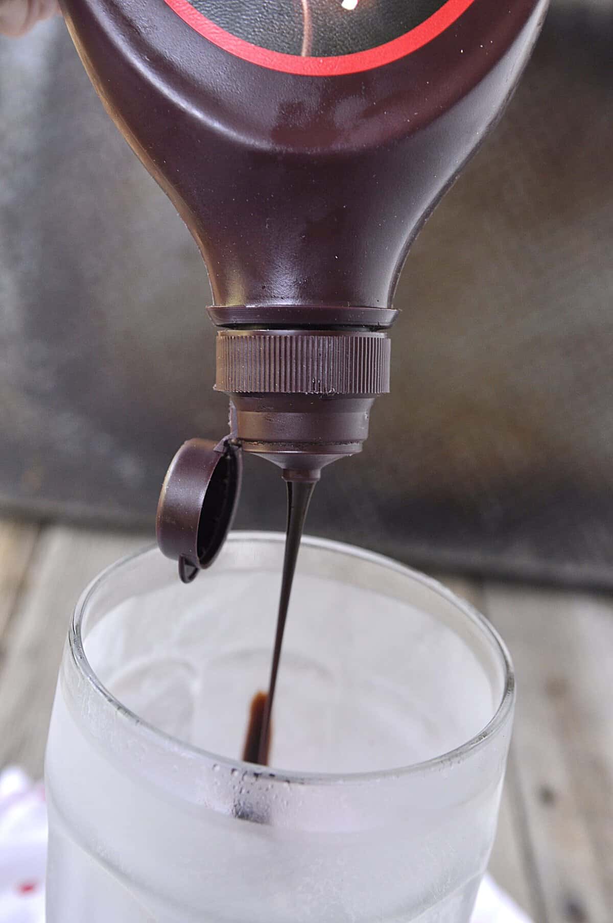 pouring chocolate syrup into a glass