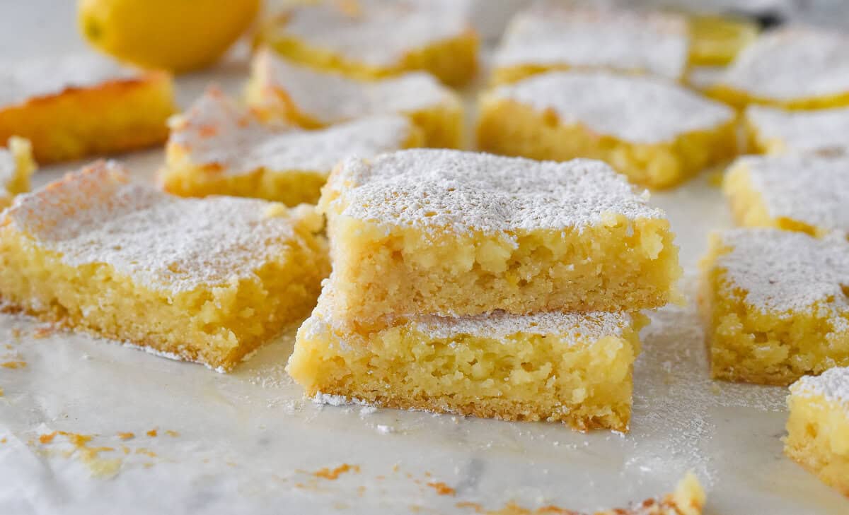 two squares of lemon ooey gooey cake stacked on top of each other