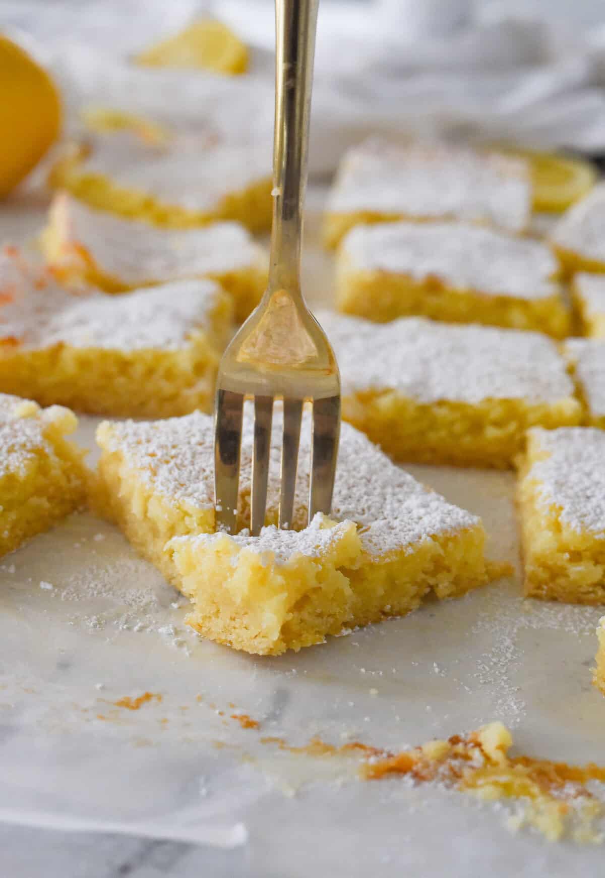 fork in a piece of lemon ooey gooey cake