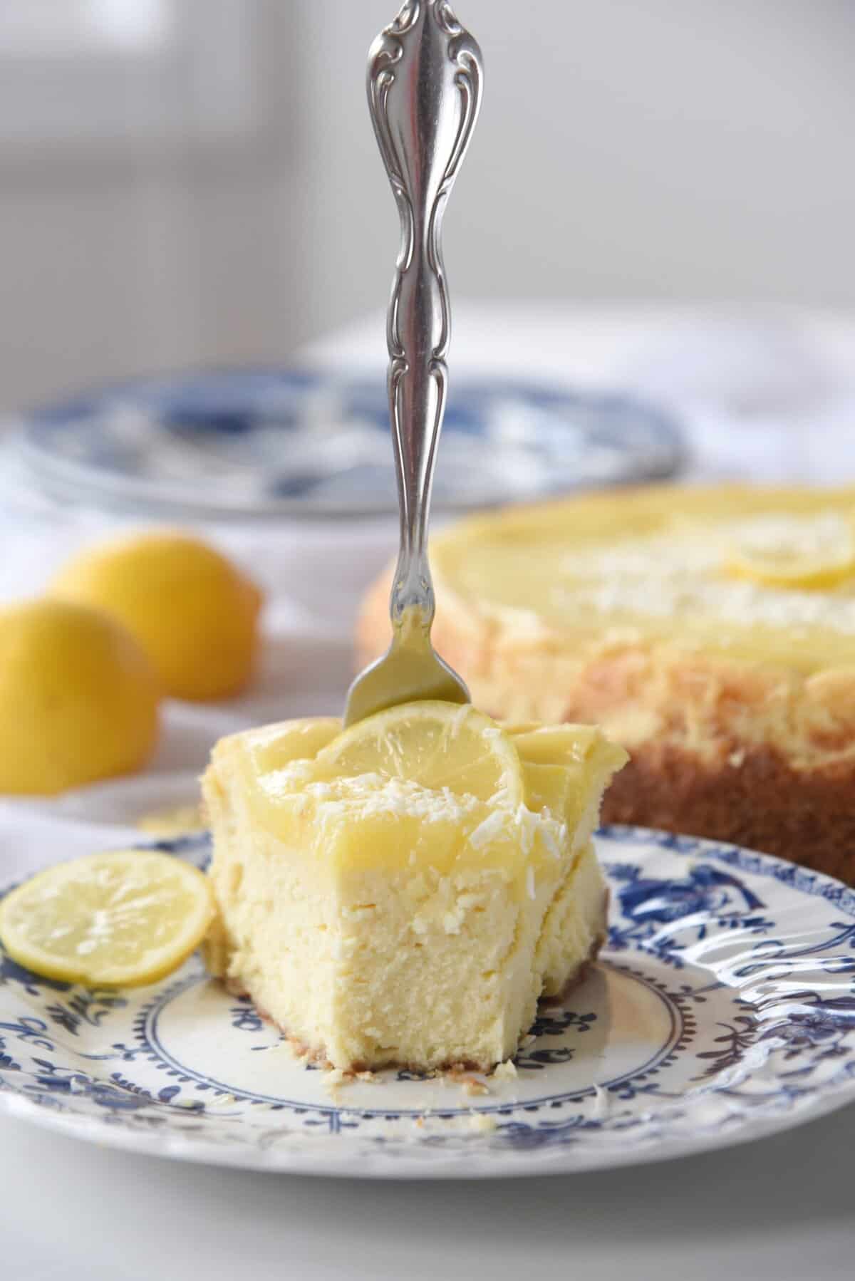 fork in a slice of lemon white chocolate cheesecake