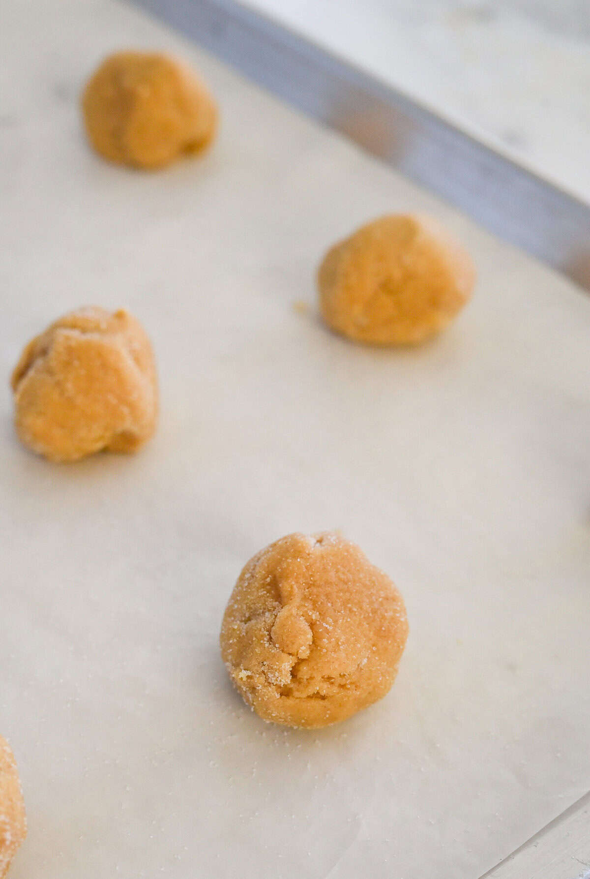 peanut butter cookie dough balls on baking sheet