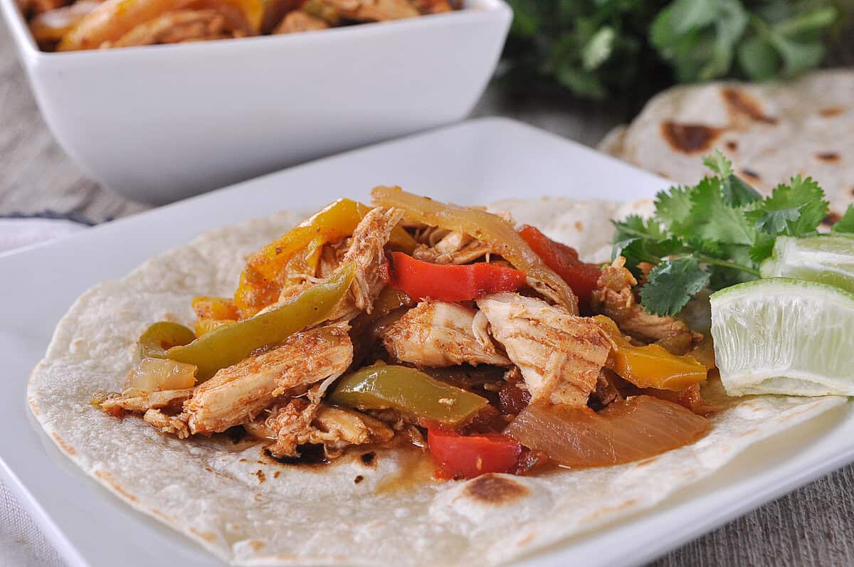 slow cooker chicken fajita on a flour tortilla