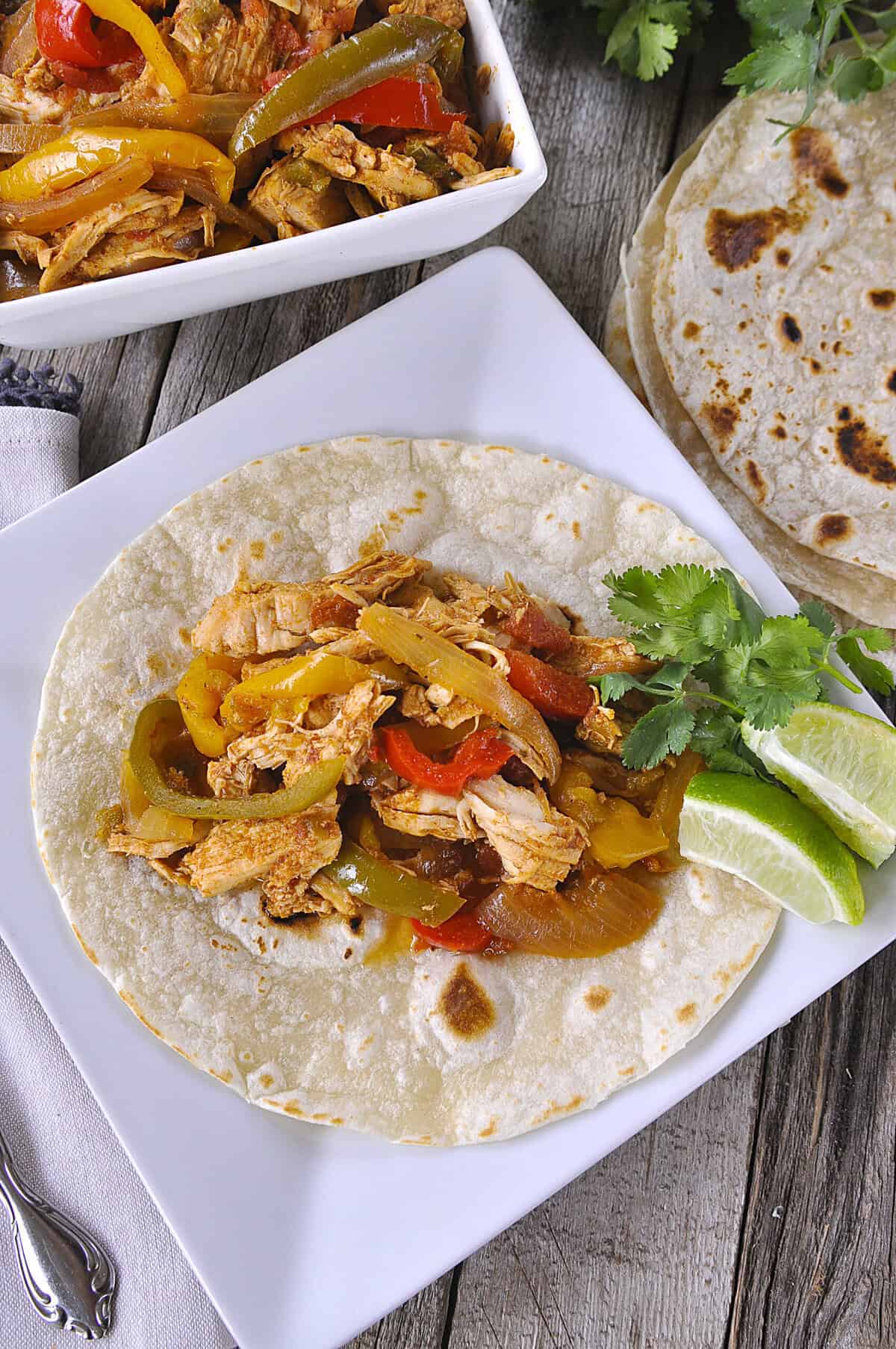 overhead shot of slow cooker chicken fajitas on a flour tortilla