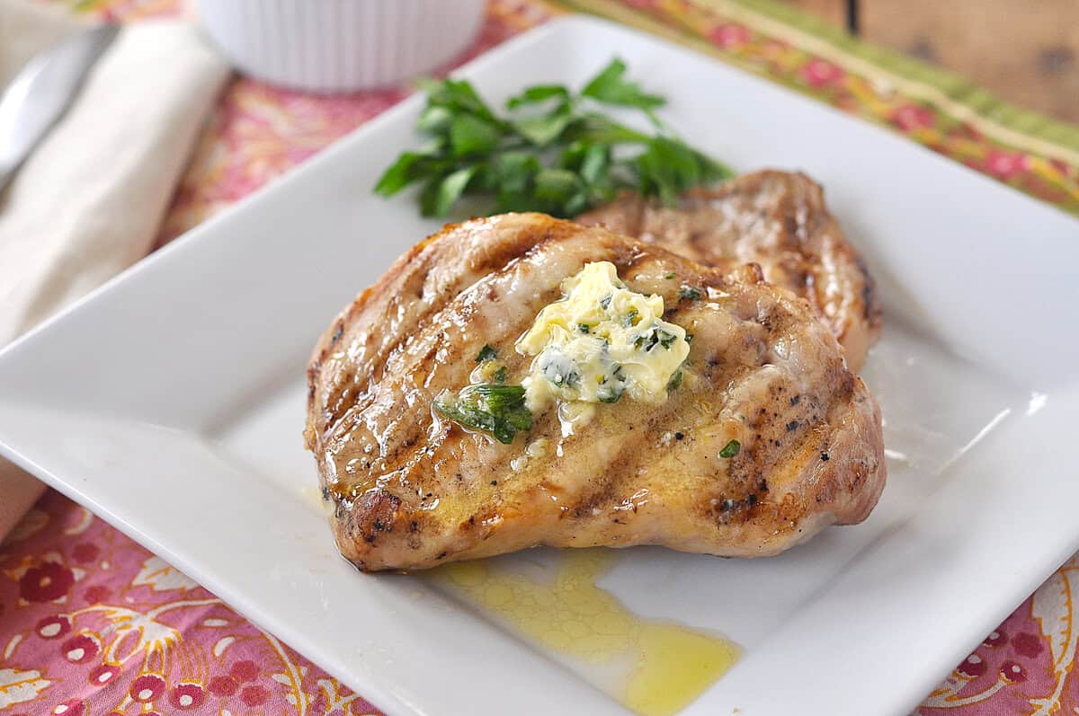 grilled pork chps on a white plate