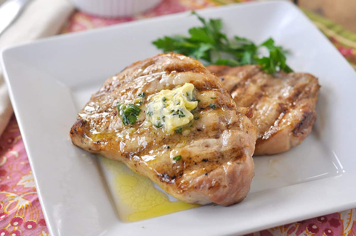 grilled pork chops two grilled brined pork chops on a white plate