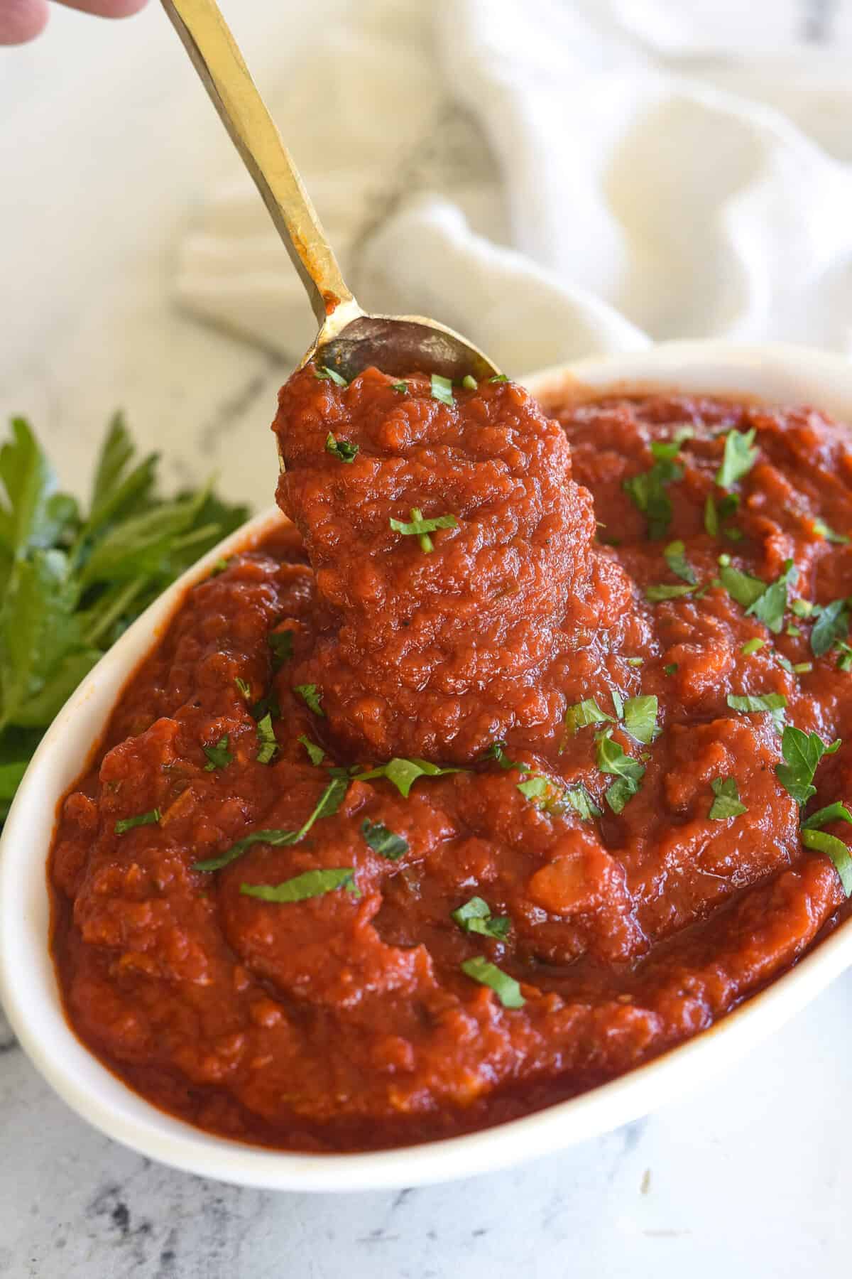 spoonful of marinara sauce in a white bowl