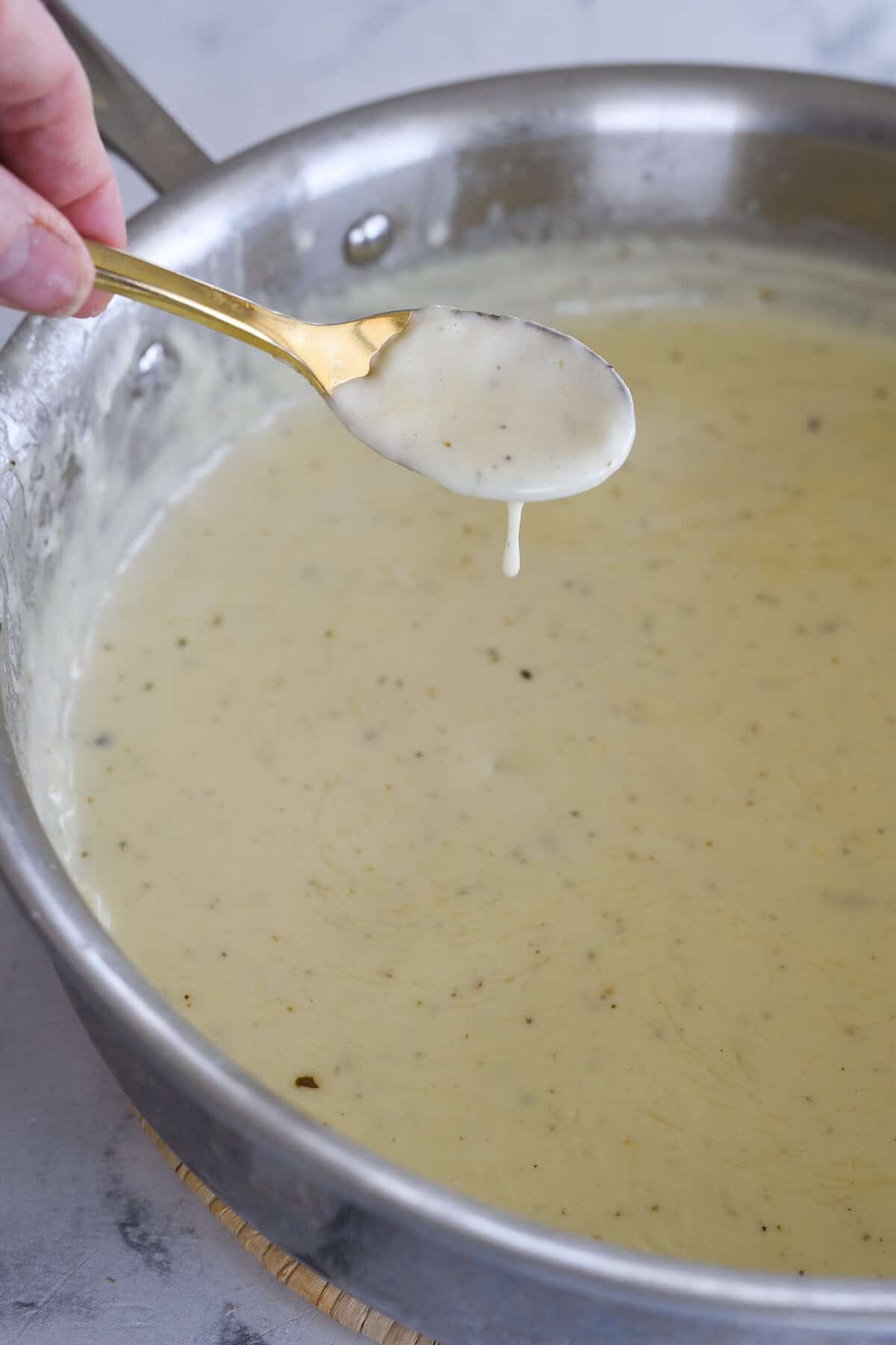 thicken alfredo sauce on a spoon
