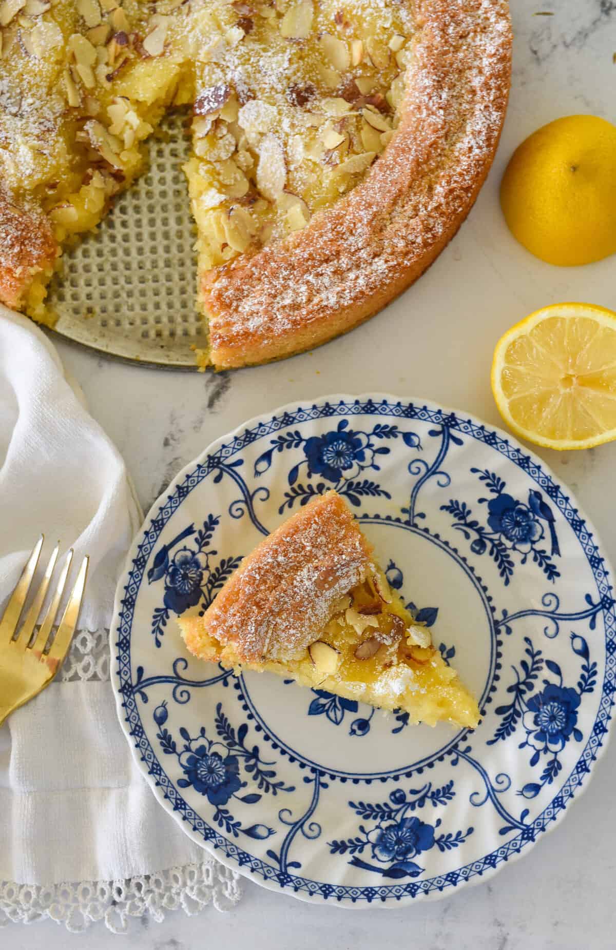 overhead shot of a slice of lemon almond butter cake on a plate