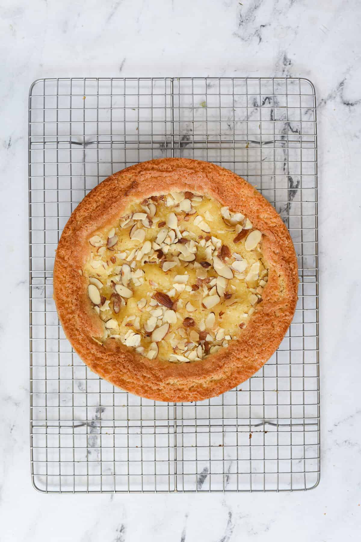 lemon almond butter cake cooling on a rack