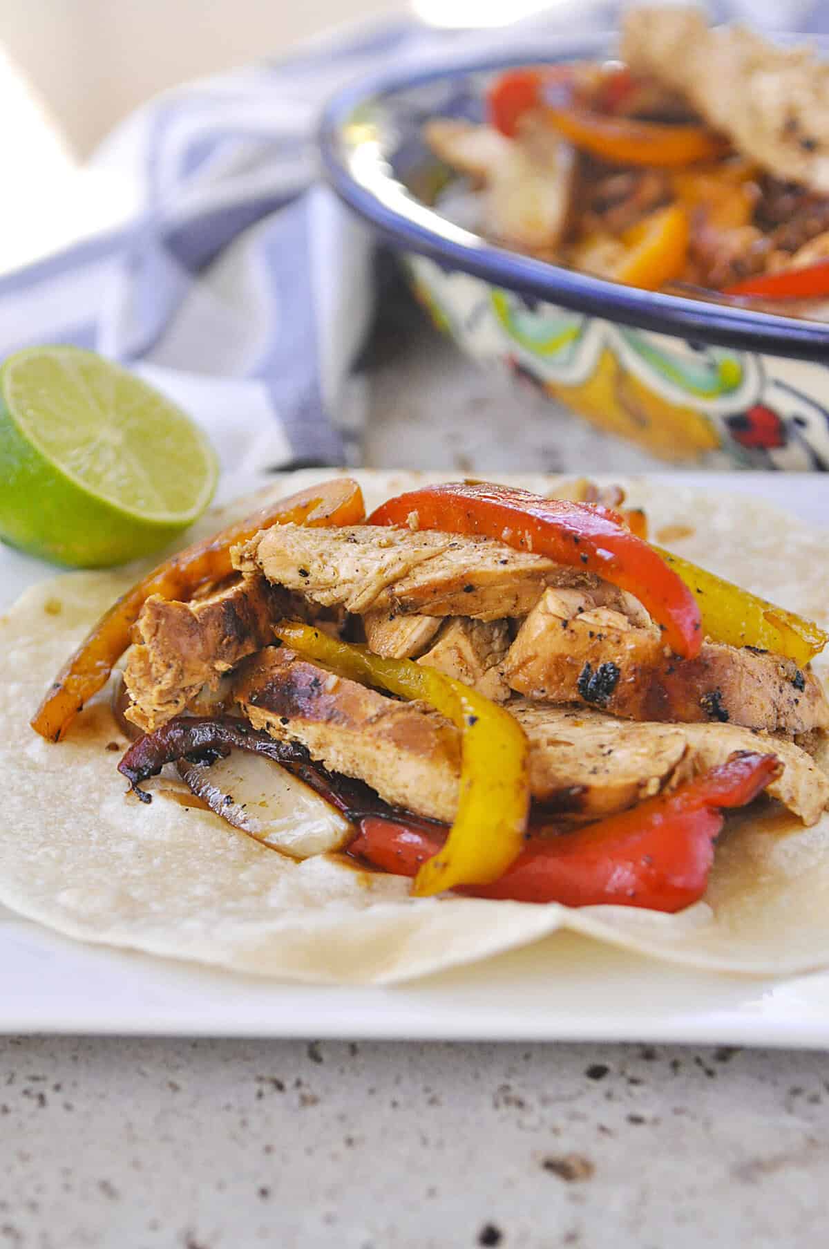 chicken fajitas on a flour tortilla on a plate