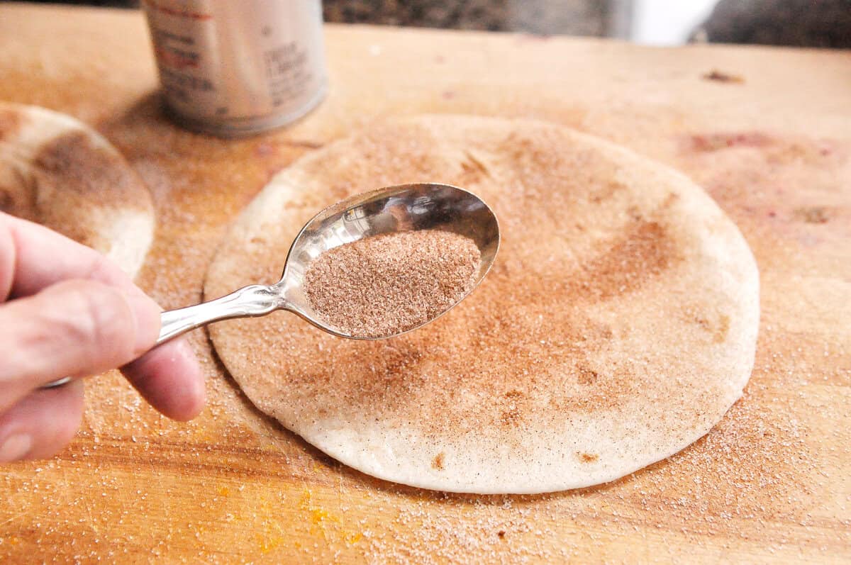 sprinkling tortilla with cinnamon sugar