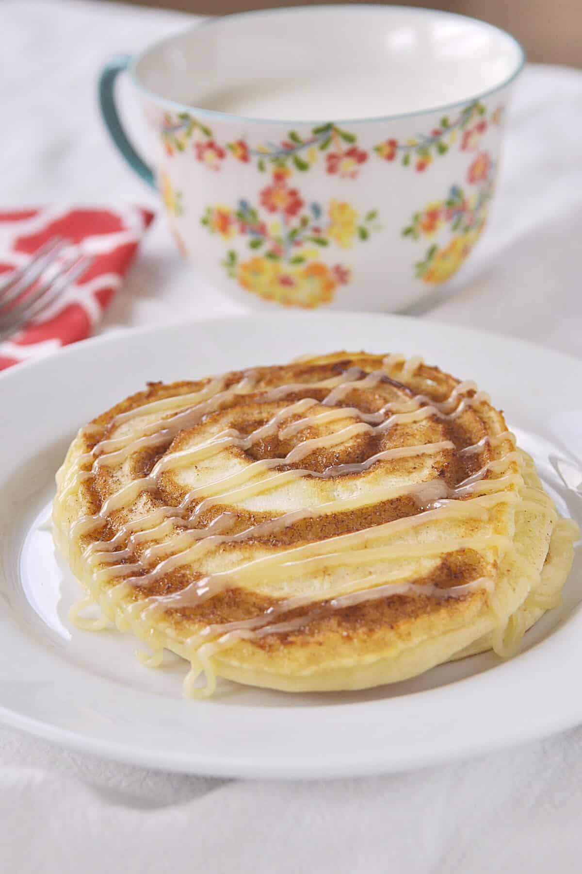 cinnamon swirl pancake with glaze on a white plate