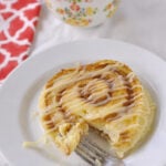 CINNAMON Roll pancakes with a bite out of it on a plate with a fork