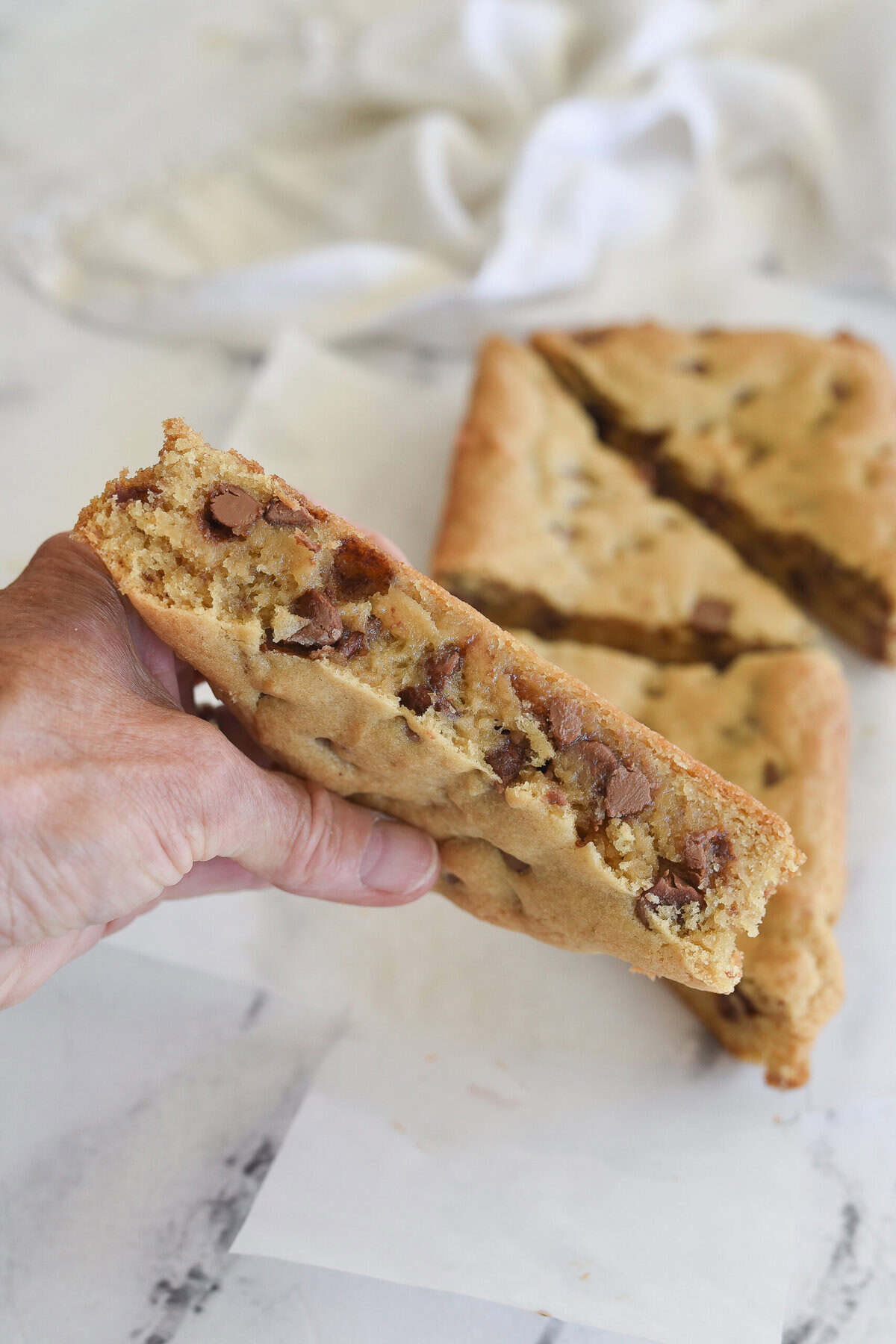 hand holding a chocolate chip cookie bar