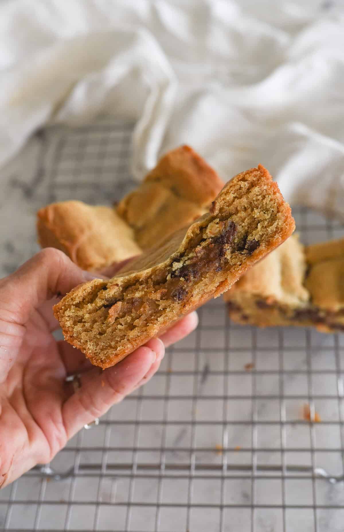 hand holding a peanut butter chocolate chip cookie bar